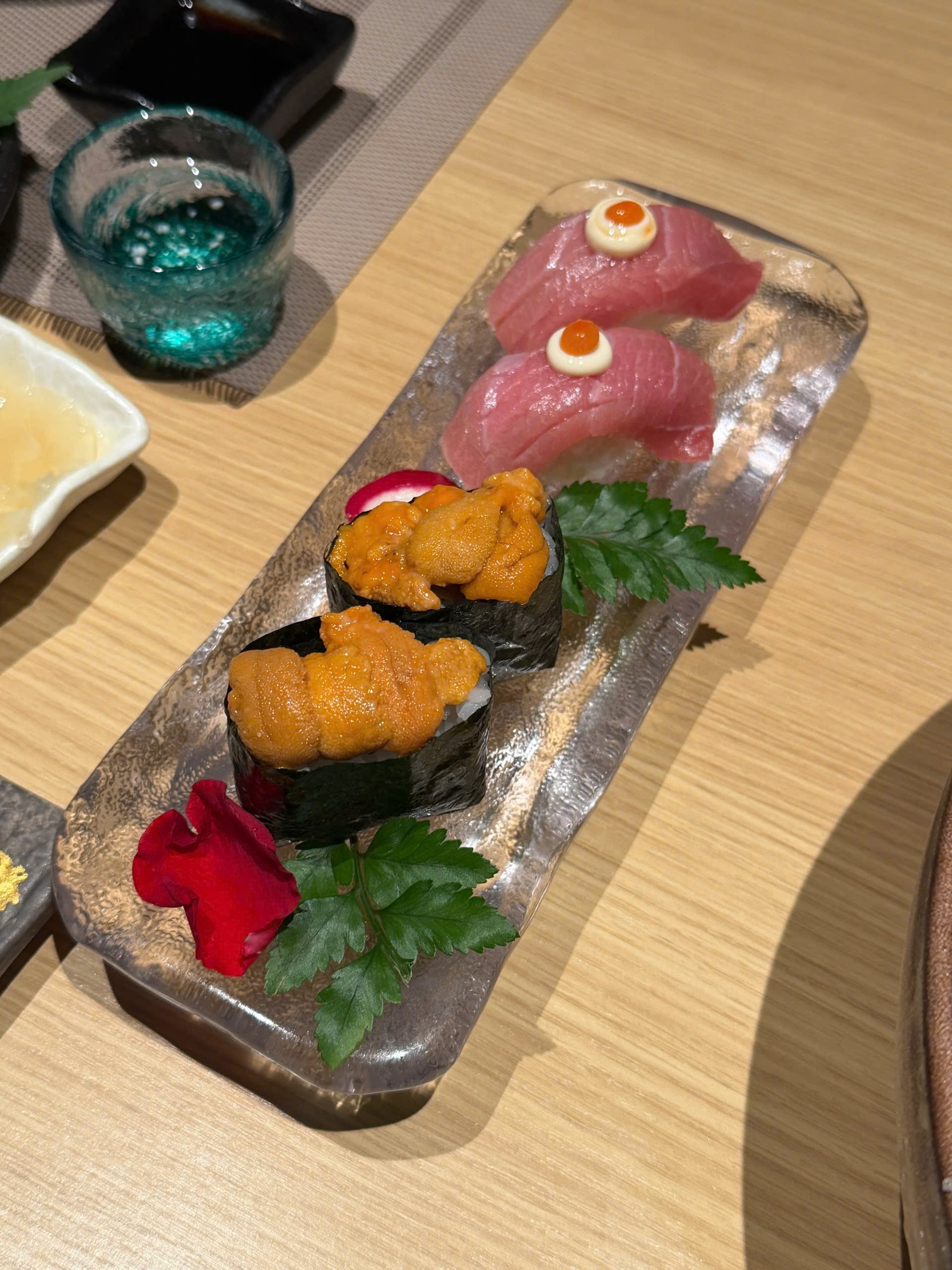 Hai miếng sushi uni và hai miếng sushi cá ngừ cao cấp trên đĩa dài