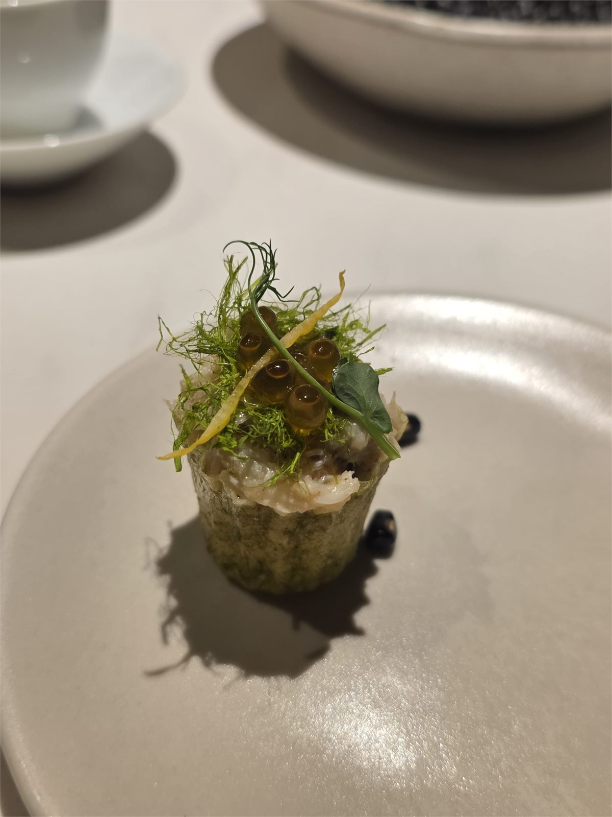 Crab pie tee trong vỏ rong biển với thịt cua, thảo mộc và các hạt sốt nhỏ